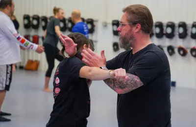 Instructor practicing self-defense wrist technique with student