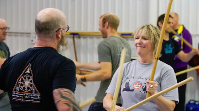Adults practicing Filipino martial arts with sticks