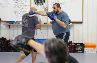 Two people practicing a self-defense move in Muay Thai class