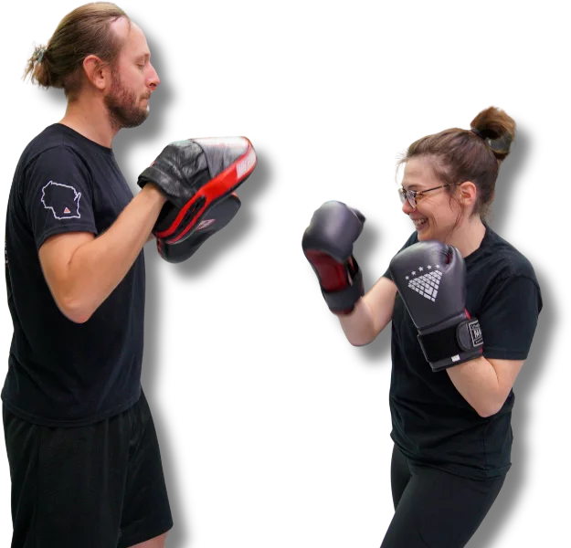 Student in gloves smiling while training pad work with partner
