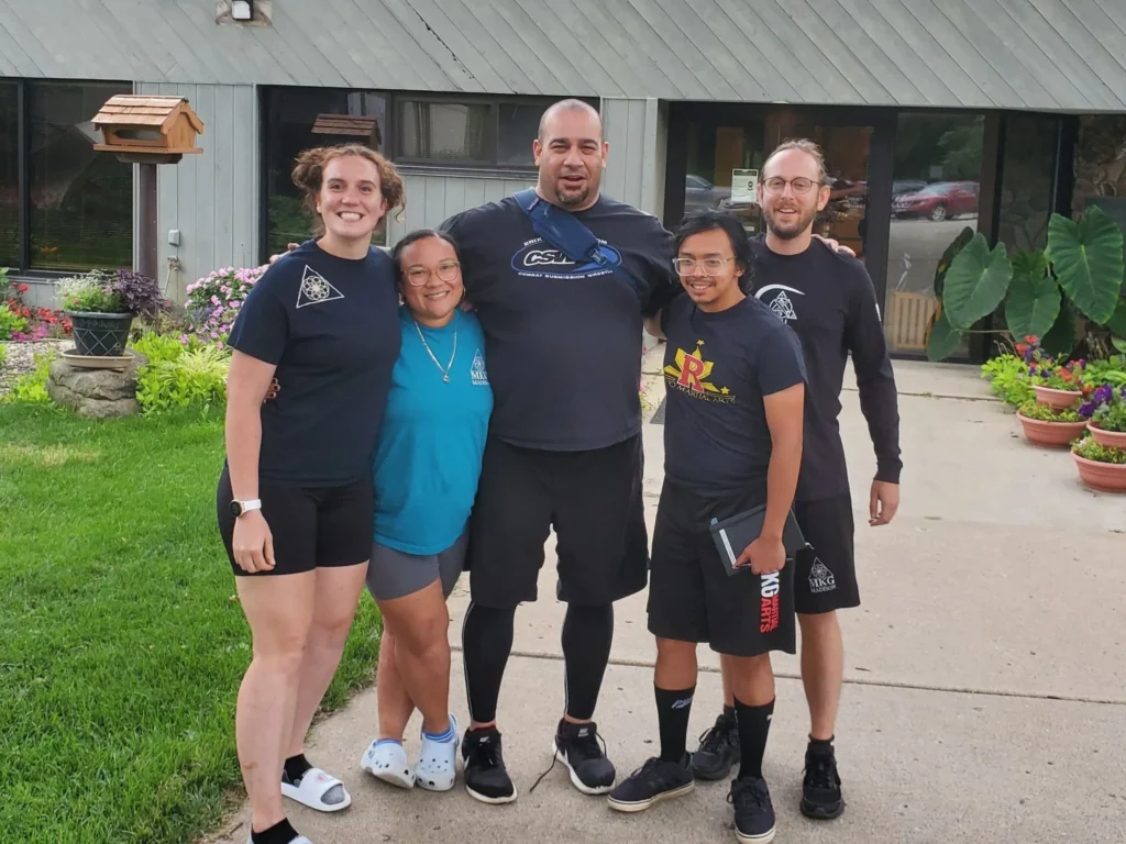 A group of standing together outside a martial arts dojo